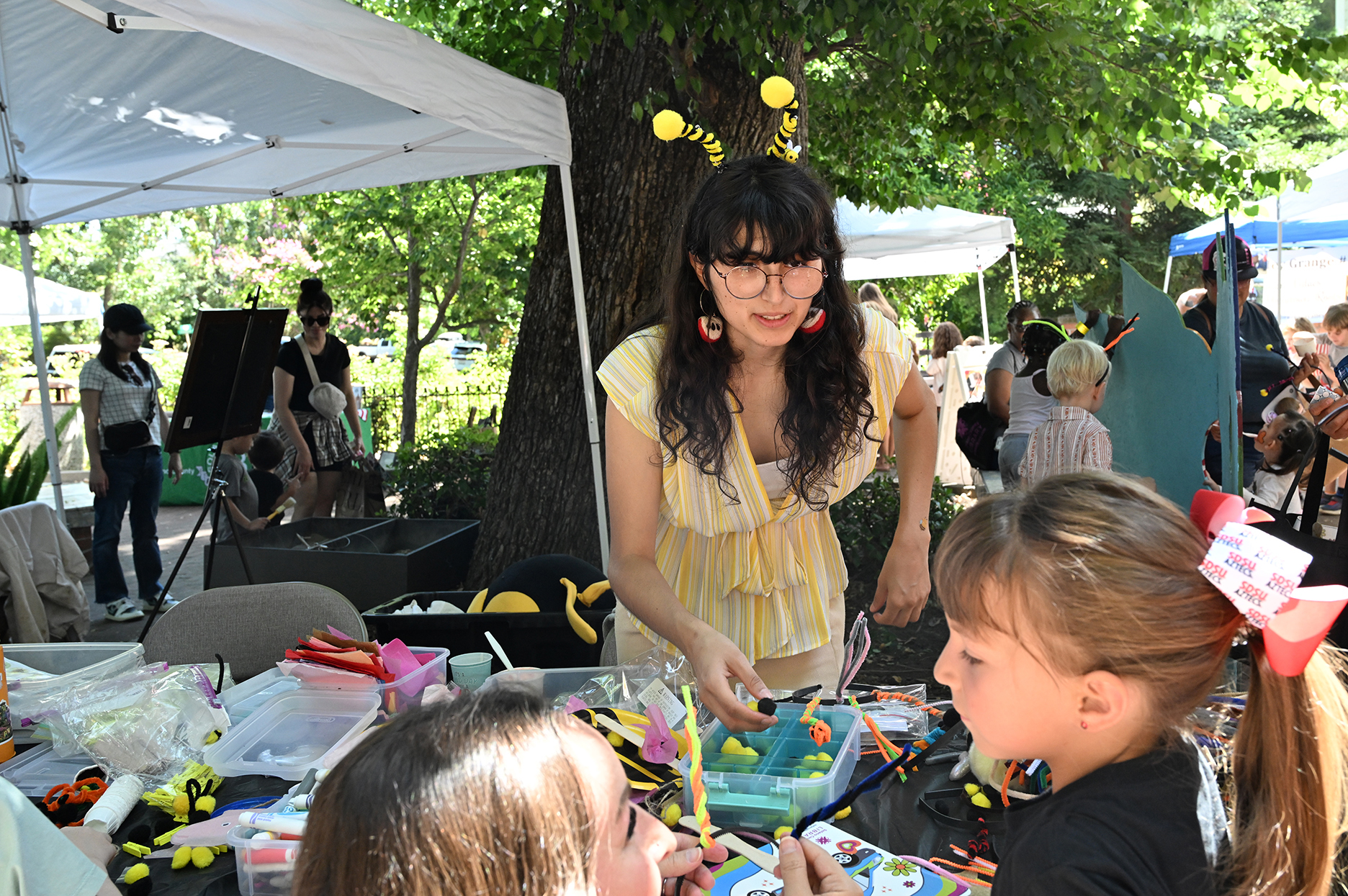 Samantha Murray, education and garden coordinator of the UC Davis Bee Haven, working with the children at the CAMBP arts and crafts table. (Photo by Kathy Keatley Garvey)