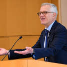 Walter Leal smiling and gesturing at wooden lectern (photograph)
